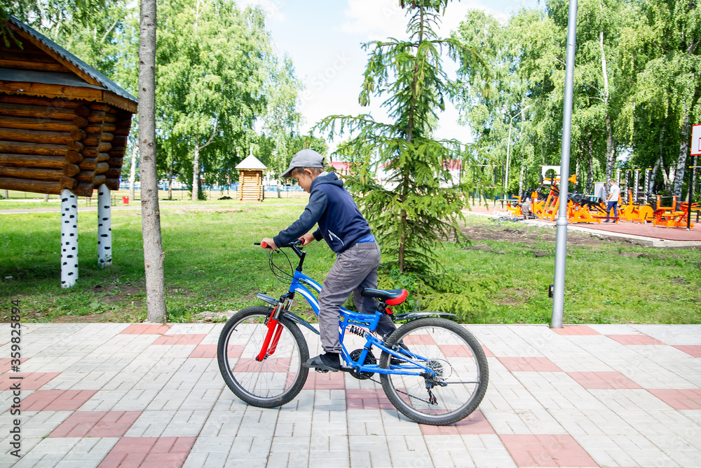 teenager rides a bicycle in the park