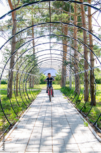 Photography little cyclist rides through a tunnel in a park