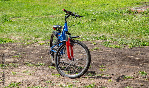 blue bicycle with a red fork stands on the road