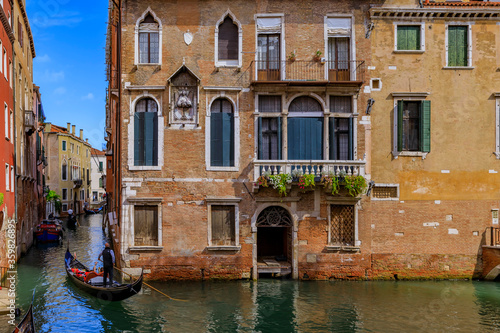 Gondola passing along buildings in a canal in Venice Italy