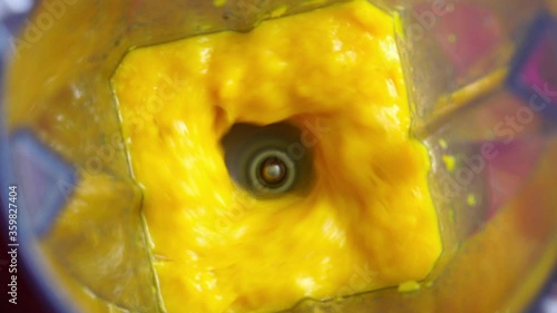 Top view of man put pieces of ripe mango into a blender to make mango smoothie. Sweet mango fruit with milk blended up to the healthy mango smoothie.