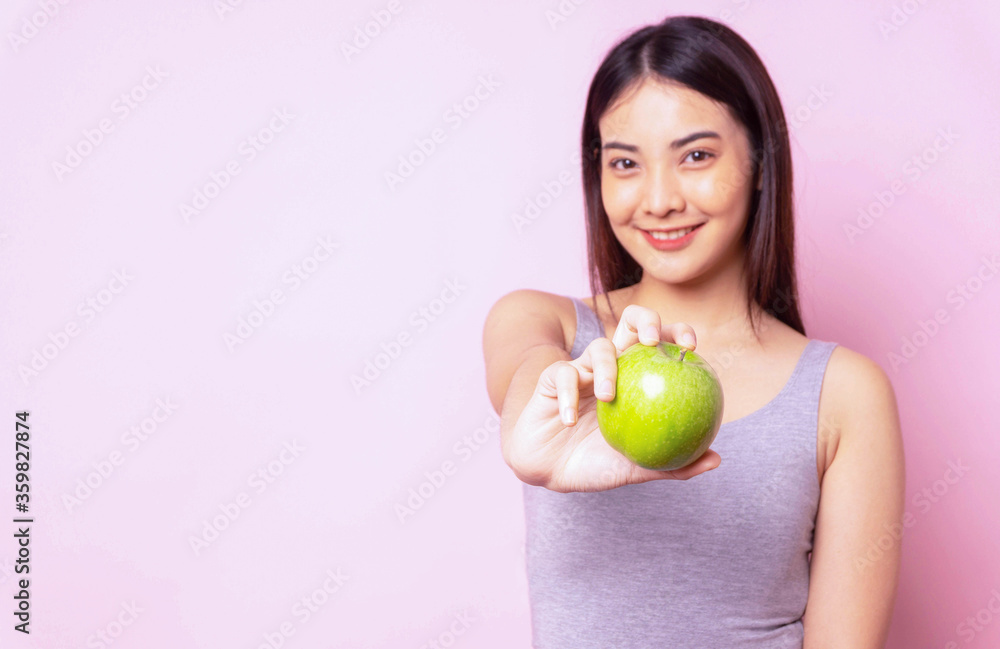 Healthy asian young woman diet holding hand with green apple fruit,orcanic food for health , sporty girl blurred person isolated portrait pink color background , copy space Healthy asian young woman diet holding hand with green apple fruit,orcanic food for health , sporty girl blurred person isolated portrait pink color background , copy space