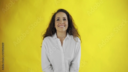 Young woman portrait with pleasure emotions on face on yellow background © stanis88