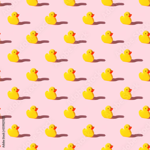 Yellow toy duck sponge or washcloth on pink background - seamless pattern. Trendy beauty bathtime wellness hygiene photography. Bath products set, creative banner, flyer