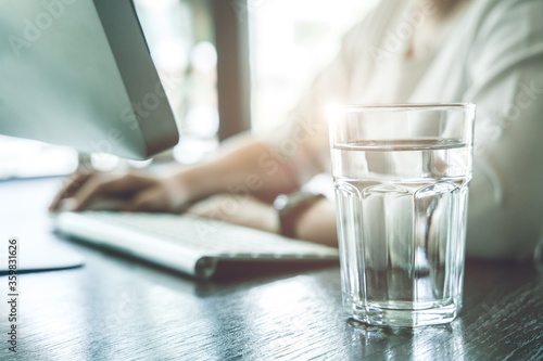 Fotografia Drink clean room temperature water during working time for healthy and stay hydrated at work
