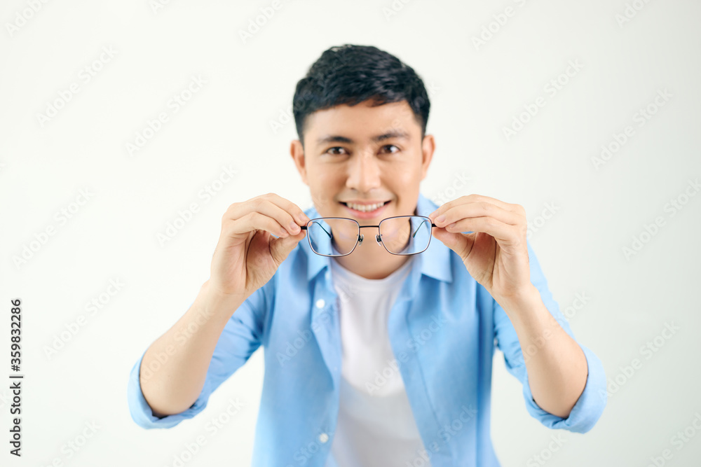 handsome man holding glasses before his eyes handsome man holding glasses before his eyes