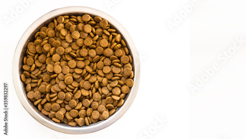 Dry Dog and Cat food.  Pile of kibbles in a metal food bowl. Top view on white backgound with copy space