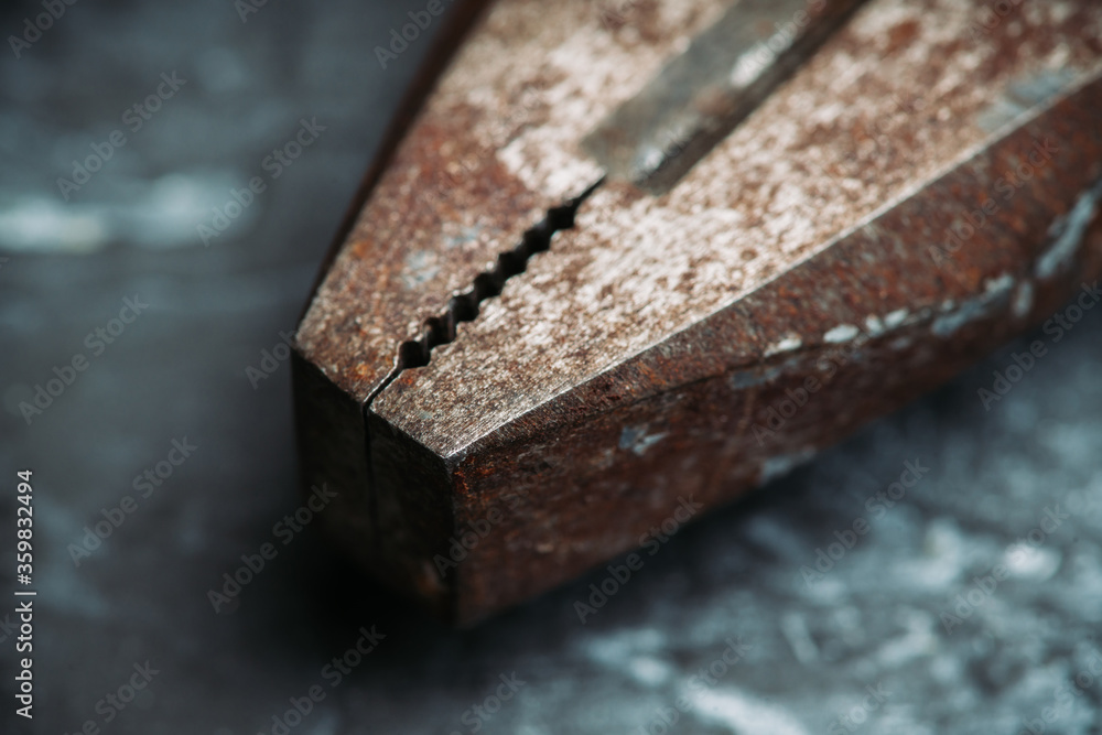 Old rusty pliers on the gray concrete background. Macro shot. Selective focus. Shallow depth of field.
Old rusty pliers on the gray concrete background. Macro shot. Selective focus. Shallow depth of field.