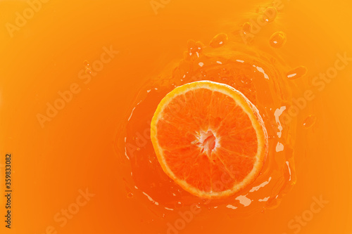 Fresh orange with orange juice splashing