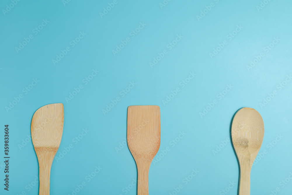 Three wooden spatulas on light blue surface. Three wooden spatulas on light blue surface.