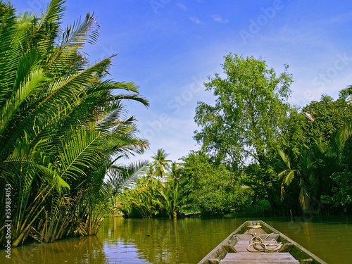 local traditional long tail boat cruise on tropical river in thailand