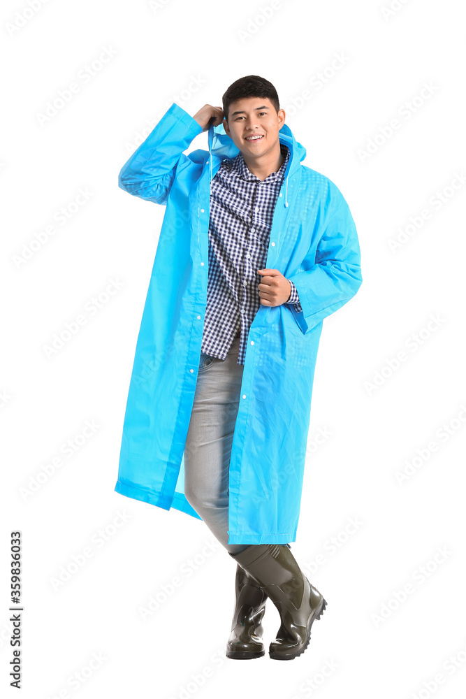 Young Asian man in raincoat on white background