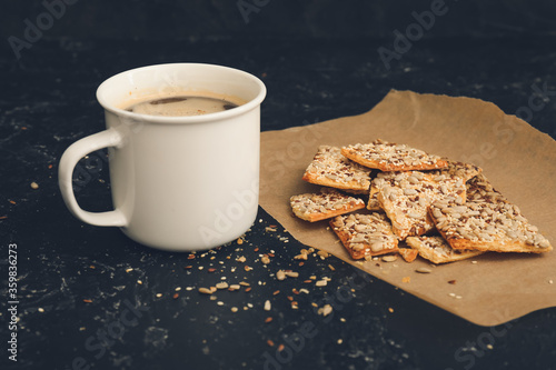 Cereal cookies and cup of coffee on dark background