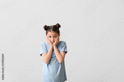 Apologizing little girl on light background
