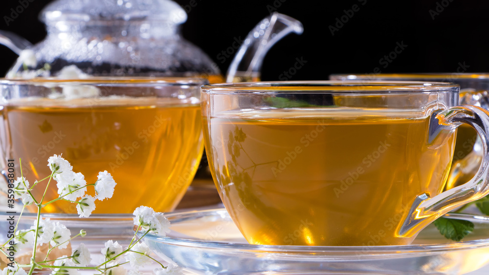 Teapot and mugs with green tea, cashew nuts, green leaves and white gypsophila flowers.Tea ceremony, traditional drink. Afternoon tea, homelike. Oriental, cozy, preparation, japanese, leafy, herbal Teapot and mugs with green tea, cashew nuts, green leaves and white gypsophila flowers.Tea ceremony, traditional drink. Afternoon tea, homelike. Oriental, cozy, preparation, japanese, leafy, herbal
