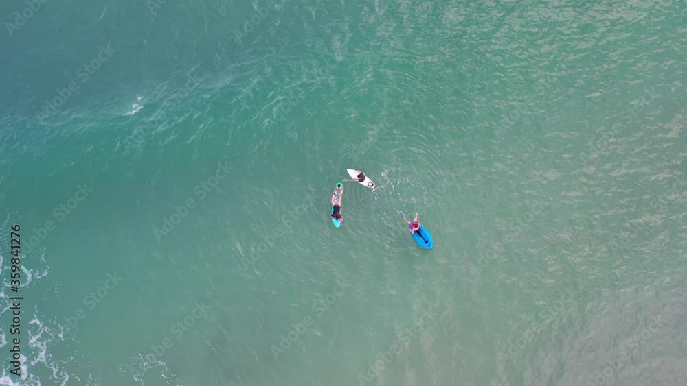 imagem aérea de bela praia com pessoas praticando surf, bodyboard, stand up e se banhando 