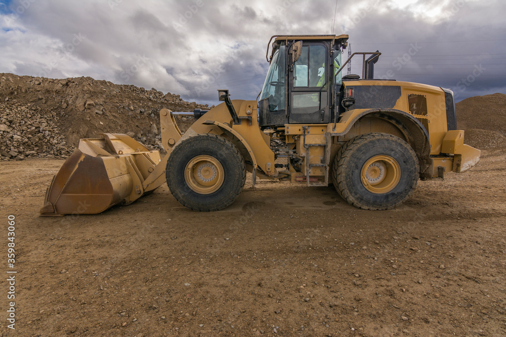 Obraz premium Yellow excavator moving earth at a construction site