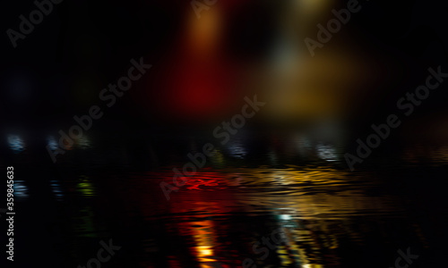 Dark street, neon lights, wet asphalt, puddles. Reflection of night lights in the water. Dark city view with neon. Dark abstract background, blur. photo