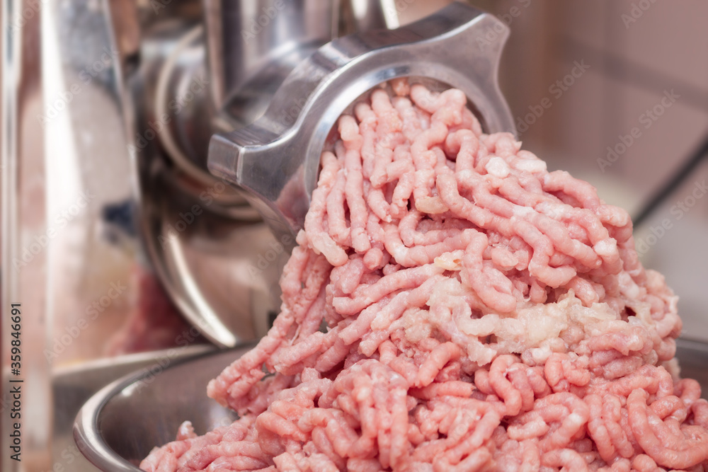 Close up of minved pork meat with onion coming out from grinder. Close up of minved pork meat with onion coming out from grinder.