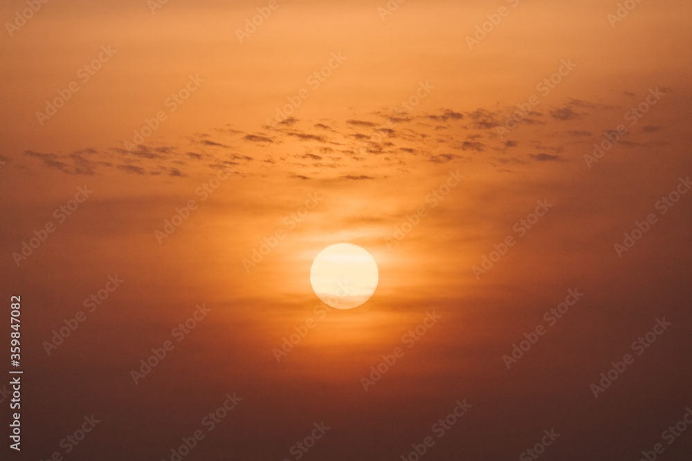 View of the sun behind the clouds during sunrise