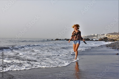 young slim woman runs on water by the sea