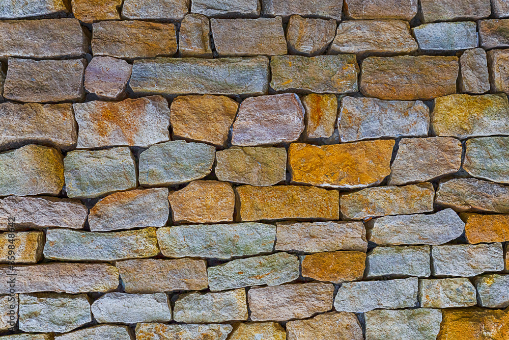 Fototapeta premium stone gray and brown old, uneven cobblestone block wall background
