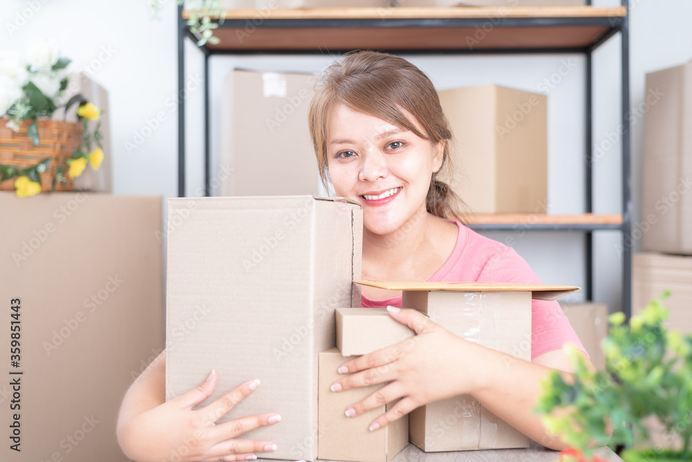 Selling online work from home. Women business owner working at home with packing box on the workplace - online shopping