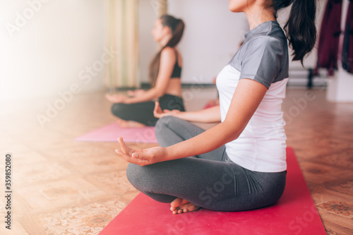 Beautiful young girls do yoga on rugs, relax, care about health