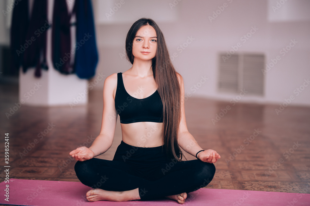 Beautiful young girl does hatha yoga on the mat, relaxes, taking care of health Beautiful young girl does hatha yoga on the mat, relaxes, taking care of health