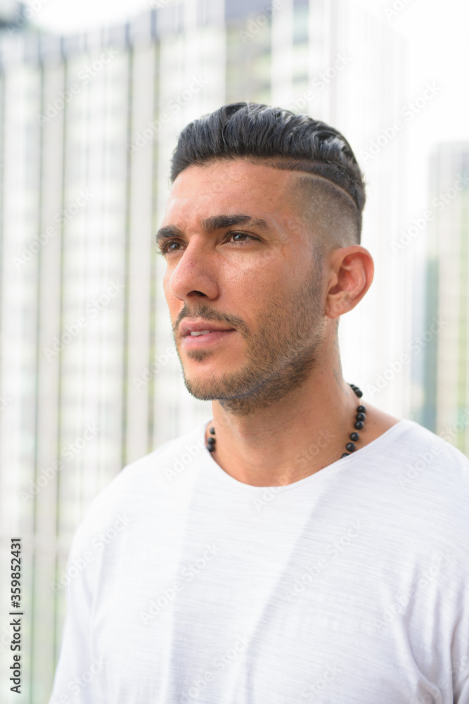 Face of young handsome bearded Persian man thinking in the city