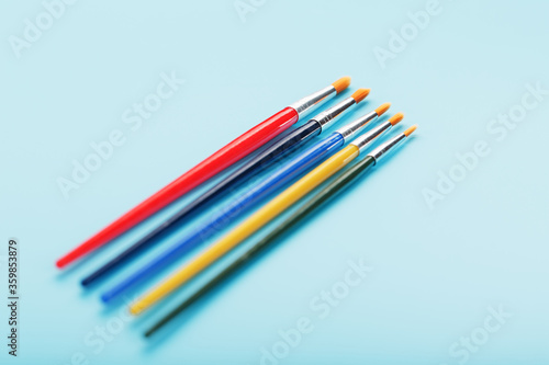 Multi-colored paint Brushes on a blue background.