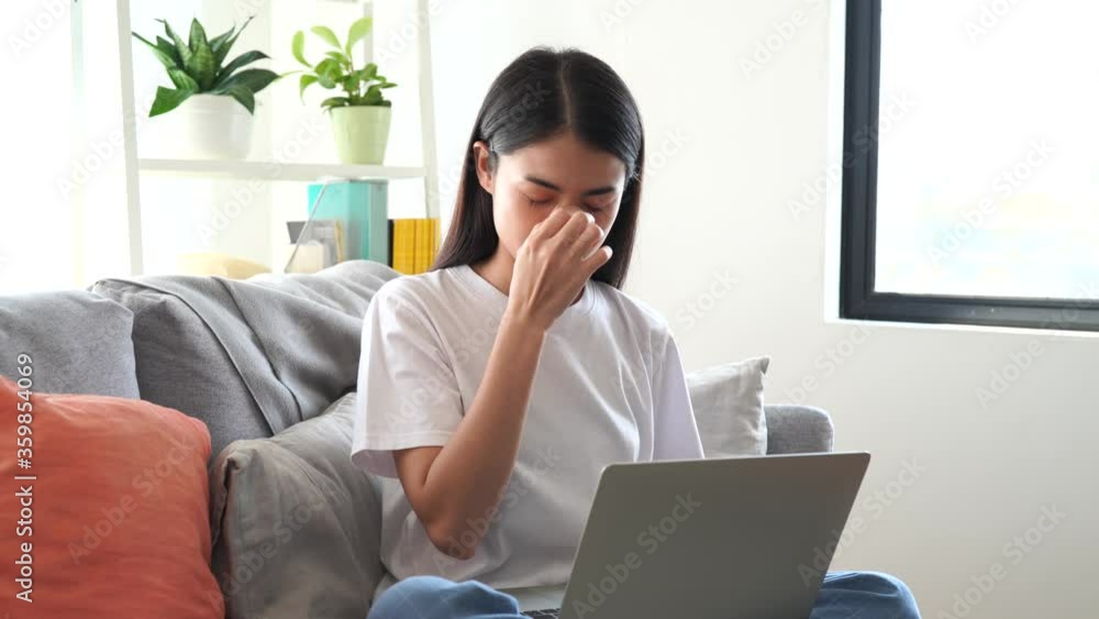 An Asian woman is tired while she is working at home. An Asian woman is tired while she is working at home.