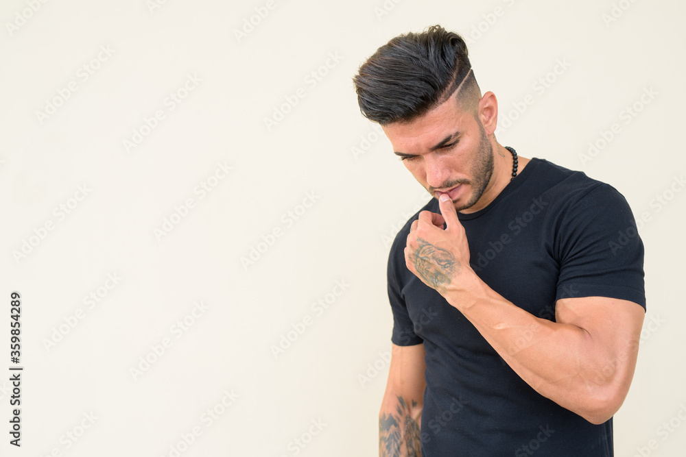 Stressed young bearded Persian man thinking and looking down Stressed young bearded Persian man thinking and looking down