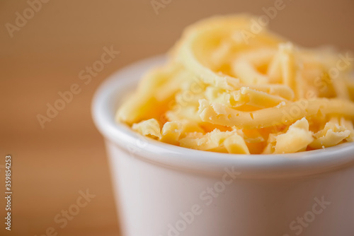 Cut cheese in a small white bowl. Snack, appetizer. Pizza ingredient.