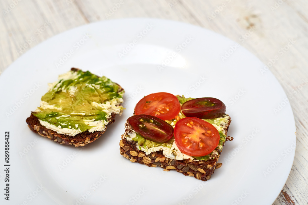 Slice of cereal bread with cream cheese, avocado and vegetables. Vegetarian sandwich. Slice of cereal bread with cream cheese, avocado and vegetables. Vegetarian sandwich.