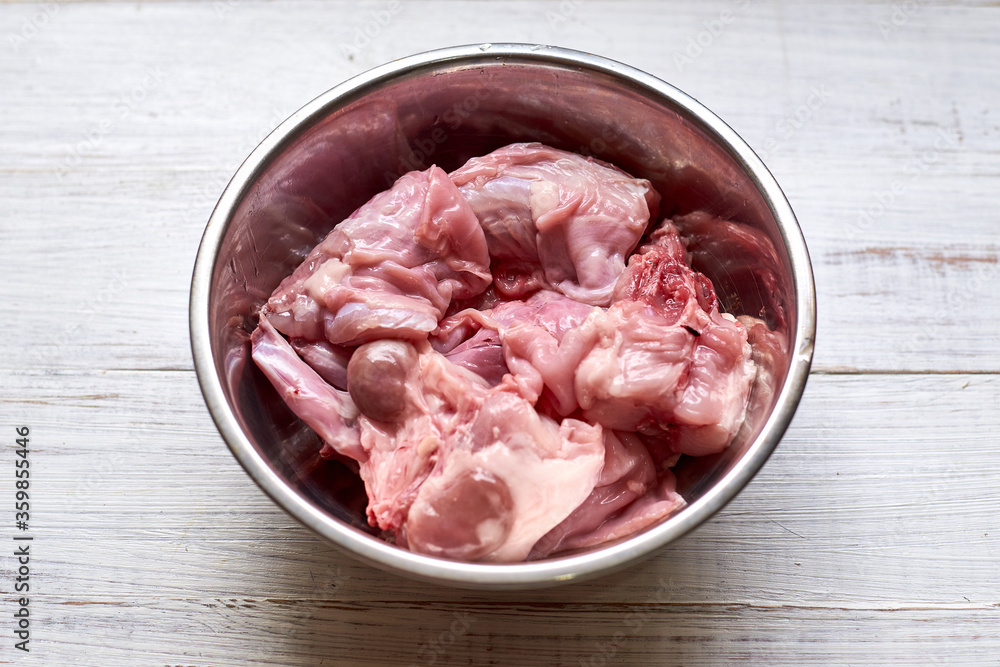 Raw rabbit in a bowl. Cutting meat, preparing for cooking. Raw rabbit in a bowl. Cutting meat, preparing for cooking.