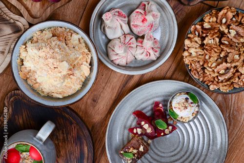 Sweet khinkali with cherry, churchhela, ice cream and nuts served on a wooden table. Traditional Georgian desserts