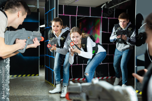 Young women having fun on dark lasertag arena