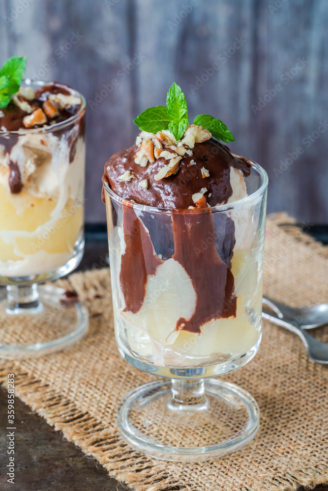 Ice cream dessert with poached pears and chocolate sauce garnished with fresh mint Ice cream dessert with poached pears and chocolate sauce garnished with fresh mint