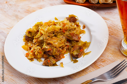 Delicious meat dish – pork with stewed cabbage served on plate