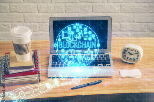 Multi exposure of blockchain theme hologram and table with computer background. Concept of bitcoin crypto currency. © peshkova