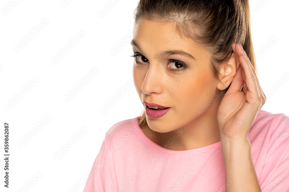 Portrait of young beautiful woman with palm behind her ear