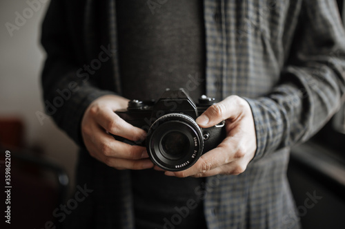 Male in dark shirt man hands holds retro camera