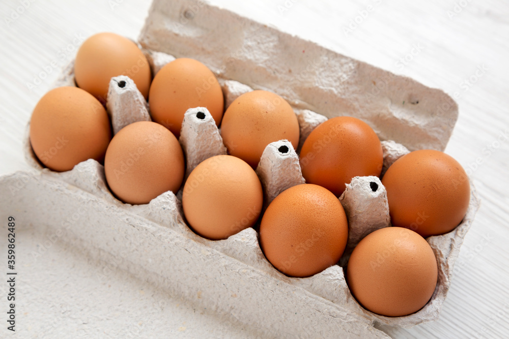 Raw Brown Eggs in a paper box, side view. Close-up. Raw Brown Eggs in a paper box, side view. Close-up.