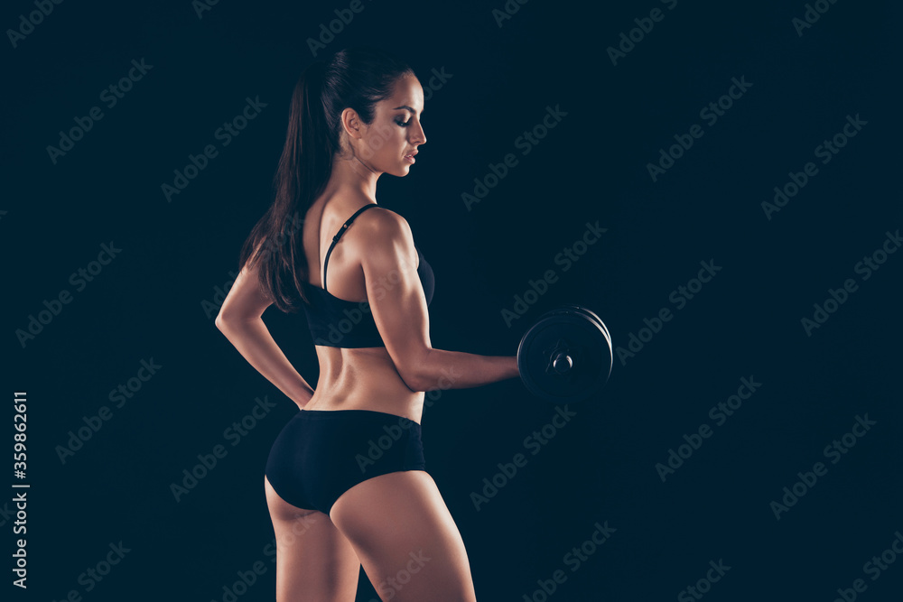 Profile side photo of focused youth athlete hold hand brunette hair hairstyle ponytails isolated over black background Profile side photo of focused youth athlete hold hand brunette hair hairstyle ponytails isolated over black background