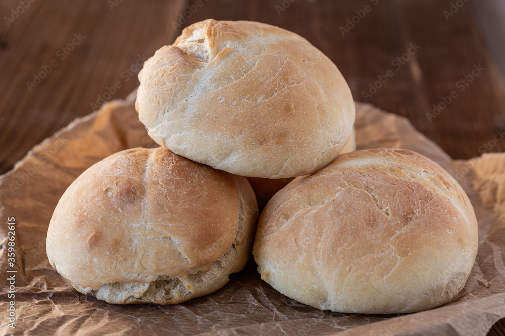 Bułki pszenne wlasnej roboty. Domowe wypieki. Swieze pieczywo na sniadanie.  Bułki na drewnianym blacie. Pieczywo w kuchni.