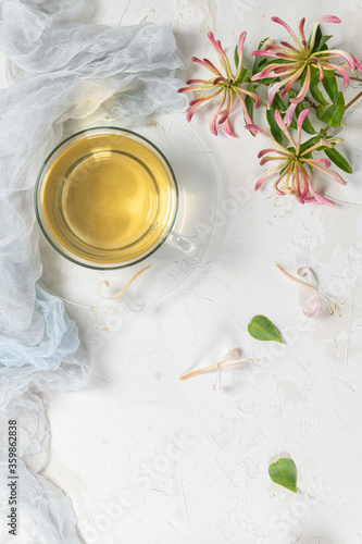 A cup of jasmine tea and jasmine flowers on a white background.