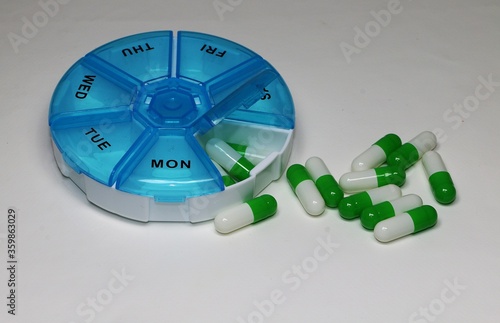 Foto weekly pillbox with green white capsules