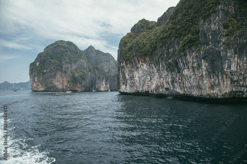 Relaxful sea holiday in Thailand, Phi-Phi island. Weekend with family at the Andaman sea. Travel by boat near the island. Waves and clouds near the sea. Image with selective focus, noise effect. Relaxful sea holiday in Thailand, Phi-Phi island. Weekend with family at the Andaman sea. Travel by boat near the island. Waves and clouds near the sea. Image with selective focus, noise effect.