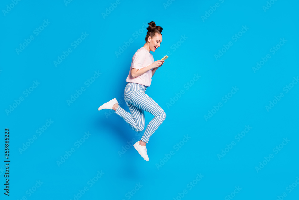 Full length body size view of her she nice-looking attractive pretty lovely addicted cheerful cheery girl jumping using digital cell chatting isolated bright vivid shine vibrant blue color background